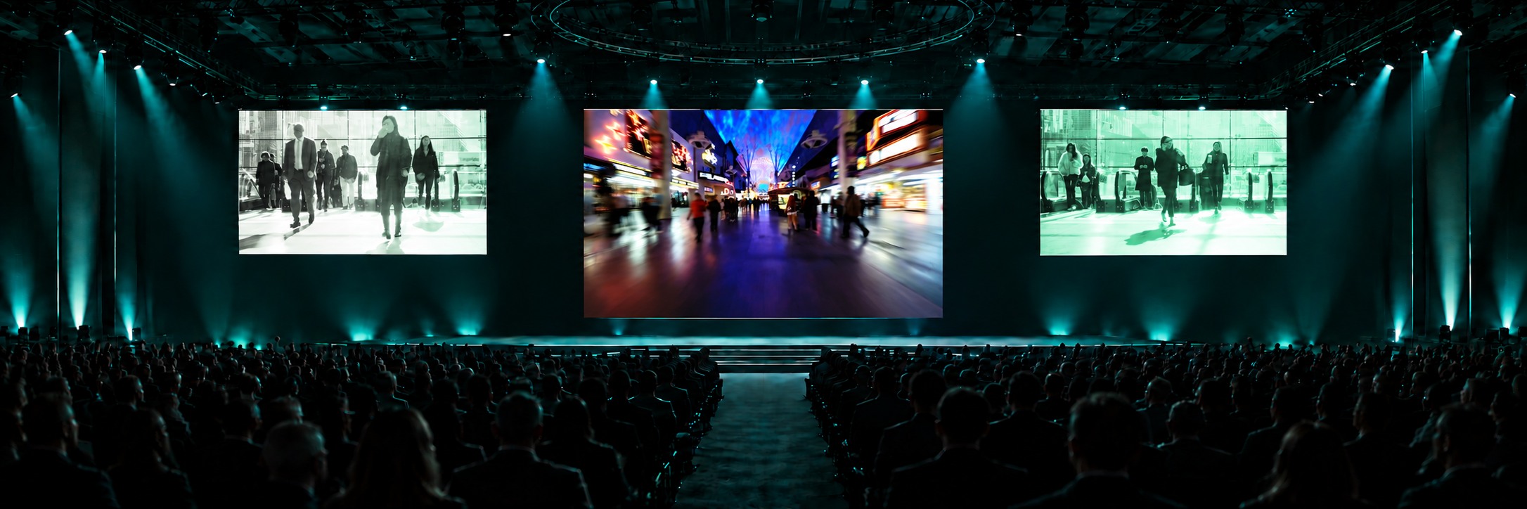 Panoramic mockup of a trade-show presentation stage with one huge 16:9 centre screen and two smaller side screens aligned to its top edge